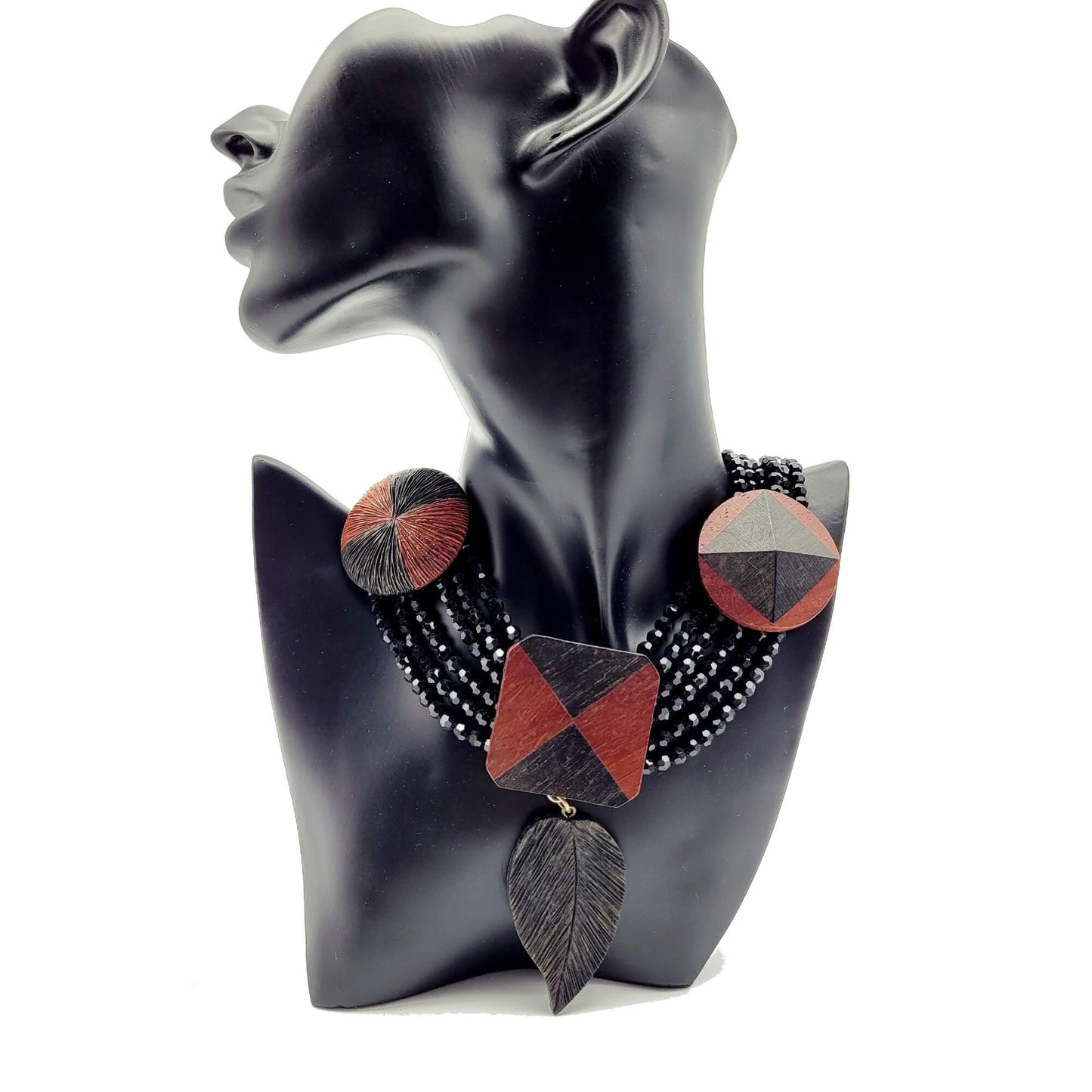 A necklace features 6 strands of black beads, with a leaf shape pendant and 3 big charms
